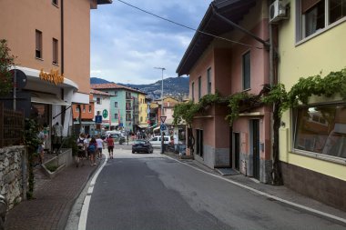 Malcesine 'in girişindeki kavşakta bulutlu bir günde insanlar geçiyor ve alışveriş yapıyorlar.