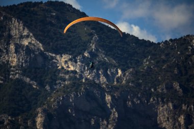 Güneşli bir günde arka planda dağ sırtlı bir paraglider