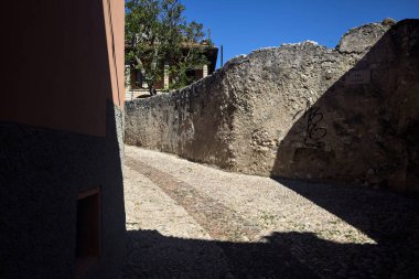 Eski bir köyde kapalı bir geçide çıkan dar kaldırımlı cadde.