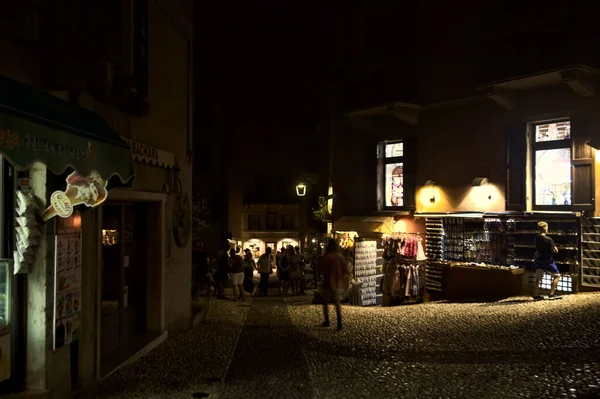 Dlážděná Úzká Ulice Osvětlenými Prodejními Okny Noci — Stock fotografie