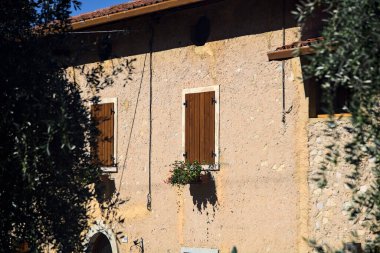 Zeytin ağaçlarının çerçevelediği eski bir malikanenin cephesi