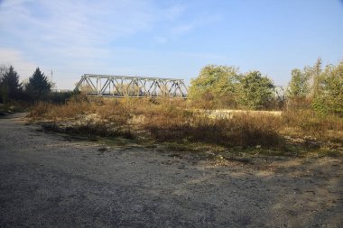 Kırsal kesimde arka planda köprüsü olan çamurlu bir yol.