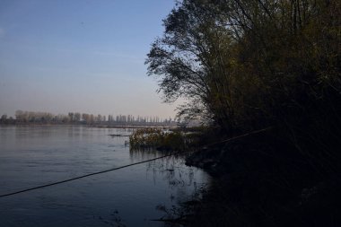 İtalya 'nın kırsal kesiminde sonbaharda kıyıdaki bir ağaç tarafından çerçevelenmiş bir nehir.