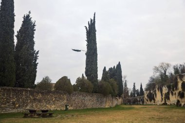 Sonbaharda bulutlu bir günde parktaki taş duvarlar arasında geniş bir patika.