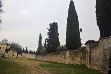 Sonbaharda bulutlu bir günde parktaki taş duvarlar arasında geniş bir patika.