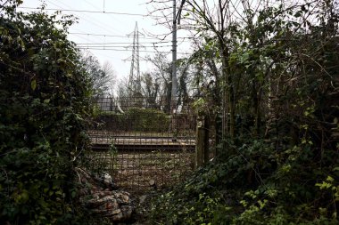 Bulutlu bir günde, parkın yanındaki duvarda açılan bir şiltenin altında.