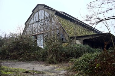 Terk edilmiş bir depo. Kışın bulutlu bir günde parkın camları kırık.