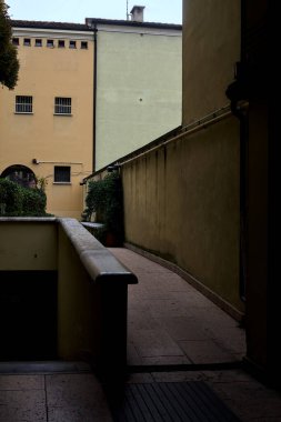 Bir avluda asfalt ve gölgedeki garaja inen patika.