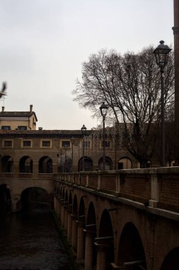 River In a town with an ancient porchway below street level on a cloudy day