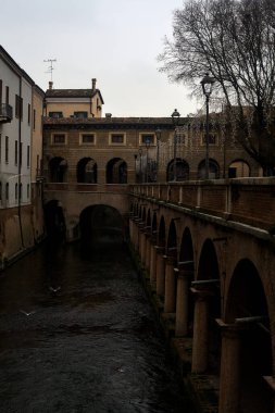 River In a town with an ancient porchway below street level on a cloudy day