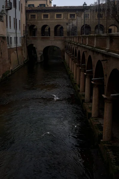 River In a town with an ancient porchway below street level on a cloudy day