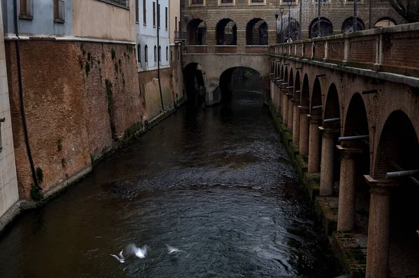 River In a town with an ancient porchway below street level on a cloudy day