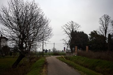 Crossroads in a group of houses on a cloudy day in the italian countryside