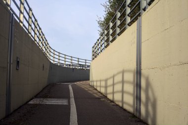 Bend in a passageway under a highway on a cloudy day
