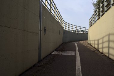 Bend in a passageway under a highway on a cloudy day