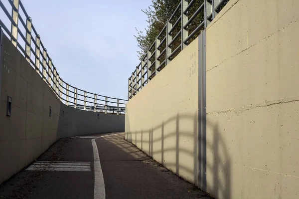 Bend in a passageway under a highway on a cloudy day