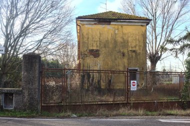 Abandoned industrial compound closed by a gate in the italian countryside
