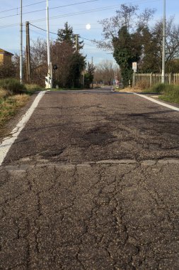Railroad crossing next to a field on a cloudy day in the italian countryside