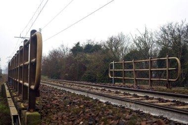 Railroad on an embankment bordered by trees on a misty day in winter