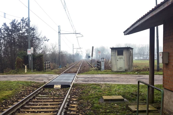 Railroad crossing in the italian countryside on a misty day in winter