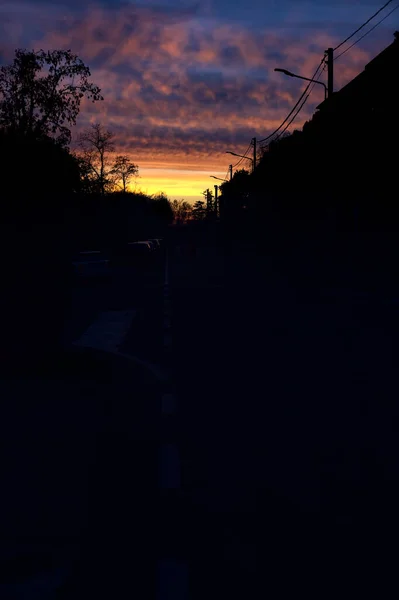 Sunset sky over a dark street of a rural town in winter