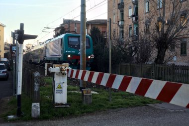 Train passing by in a rural town at sunset