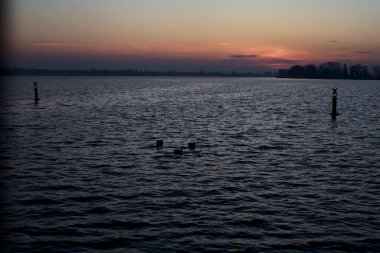 Lake at sunset with the opposite shore on the horizon