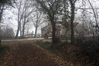 Entrance gate to a park on a fogy day in the italian countryside in winter