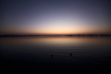 Gün batımında göl ve suya düşen gökyüzü.