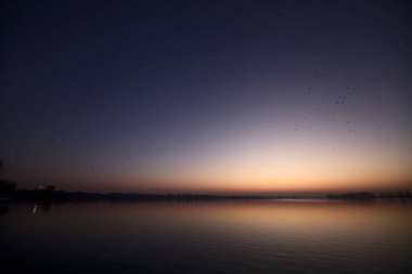 Gün batımında göl ve suya düşen gökyüzü.