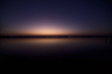 Gün batımında göl ve suya düşen gökyüzü.