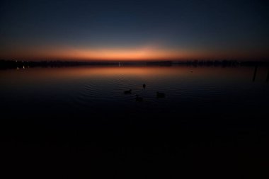 Gün batımında göl ve suya düşen gökyüzü.