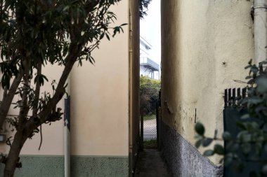 Small passage between buildings in a village on a foggy day