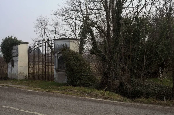 曇りの日にイタリアの田舎の道路の端によって積極的なニッチで閉じたゲート — ストック写真