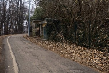 Bulutlu bir günde evin giriş kapısı olan bir dağdaki parkta yol.