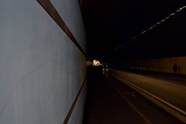 İtalya 'da bir uçurumun altından geçen insanlar ve arabalarla dolu bir tünel.