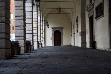 Bulutlu bir günde İtalyan şehrinde tarihi bir binanın gölgesinde kısmen sundurma.