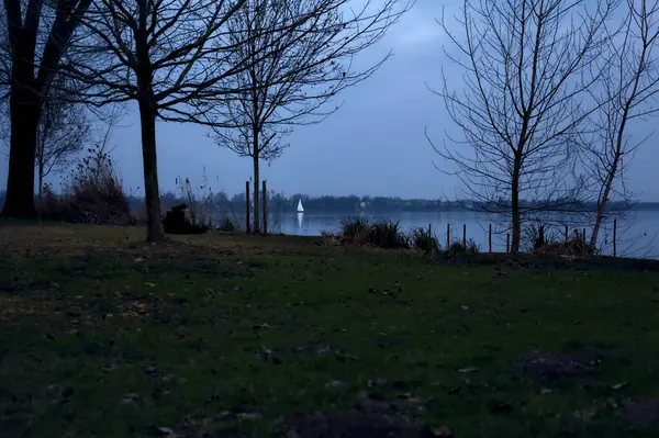 Lake Bij Zonsondergang Een Zeilboot Verte Gezien Vanaf Kust Een — Stockfoto