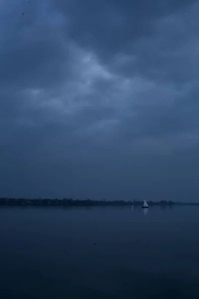 Jezioro Zachodzie Słońca Pochmurny Dzień Żaglowcem Oddali — Zdjęcie stockowe