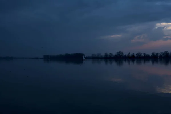 Λίμνη Στο Ηλιοβασίλεμα Μια Συννεφιασμένη Μέρα Ένα Ιστιοφόρο Στο Βάθος — Φωτογραφία Αρχείου