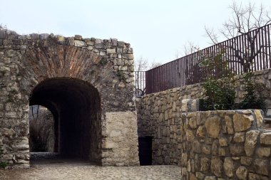 Bulutlu bir günde parktaki bir kalenin gizli geçidine giriş.