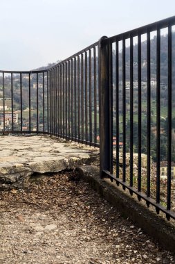 Parkta ve yamaçta arka planda binalar olan panoramik balkon.