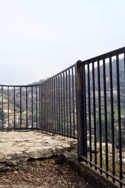 Parkta ve yamaçta arka planda binalar olan panoramik balkon.