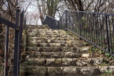 Bulutlu bir günde parktaki parmaklıklı merdiven.