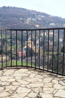 Parkta ve yamaçta arka planda binalar olan panoramik balkon.