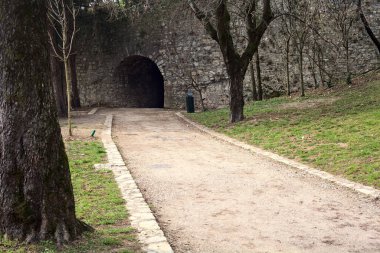 Bulutlu bir günde parktaki bir kalenin gizli geçidine giriş.