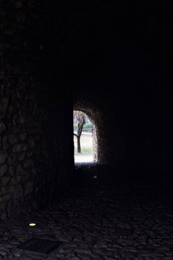 Bir kalenin sınır duvarında karanlık ve örtülü bir geçit.