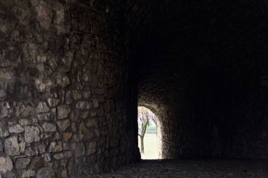 Bir kalenin sınır duvarında karanlık ve örtülü bir geçit.