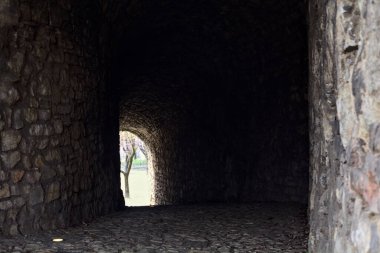 Bir kalenin sınır duvarında karanlık ve örtülü bir geçit.