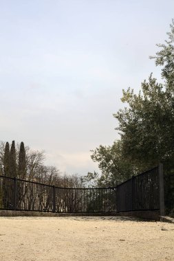 Parkta ve yamaçta arka planda binalar olan panoramik balkon.